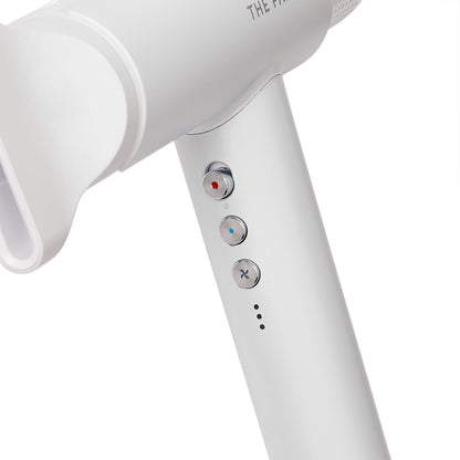 closeup of the buttons on the handle of a white hair dryer 